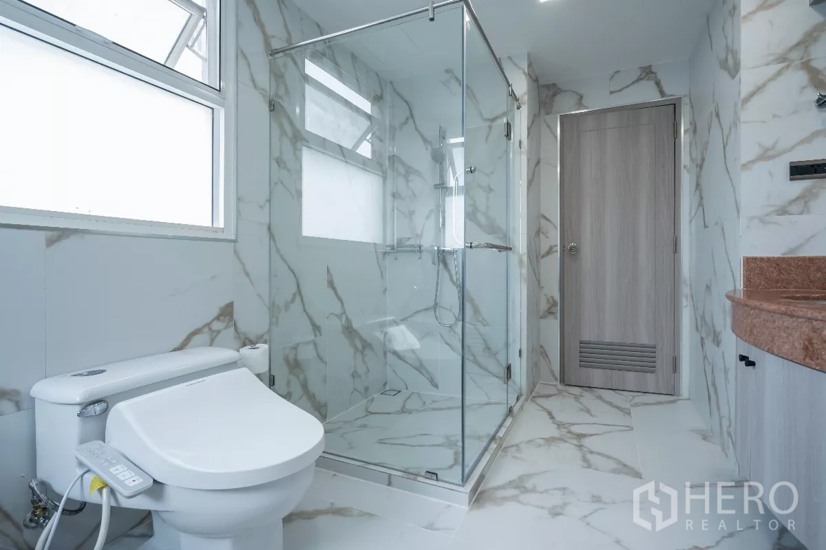 Apartment for rent - Marble bathroom with glass shower, bidet toilet and window.