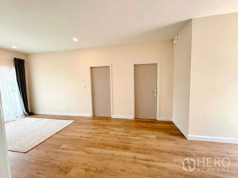 บ้าน ขายในLat Krabang, Bangkok - ห้องสว่างพื้นไม้ มีประตูภายในสองบานและผ้าม่านโปร่ง