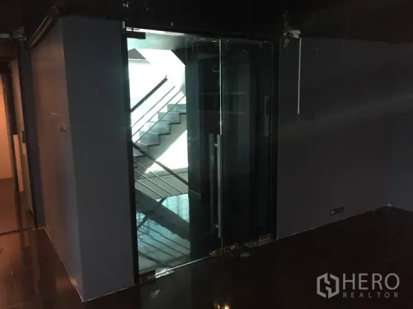 零售空间 出租在Khlong Toei, Bangkok - 入口处双扇玻璃门，可见楼梯与走廊区域。