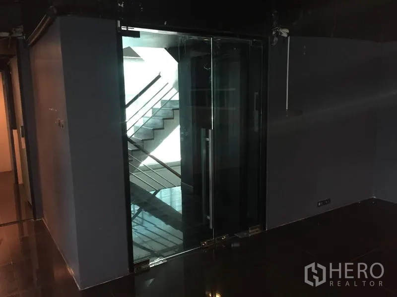 零售空间 出租在Khlong Toei, Bangkok - 入口处双扇玻璃门，可见楼梯与走廊区域。
