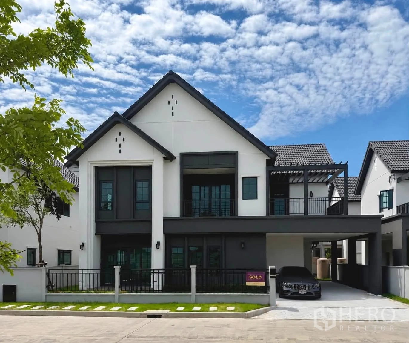 บ้านเดี่ยว for rent or sale in Bang Phli, Samut Prakan - ด้านหน้าบ้านเดี่ยวสองชั้นสมัยใหม่ มีที่จอดรถในร่มและสนามหญ้าหน้าบ้าน