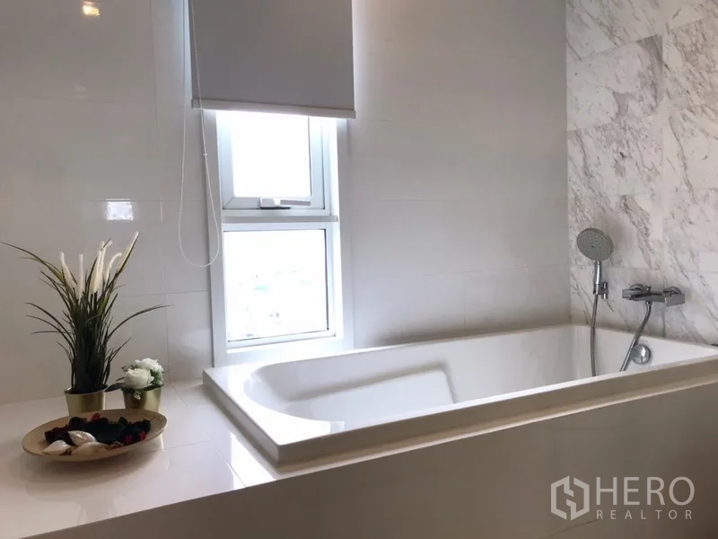 公寓 出租在Watthana, Bangkok - 带窗浸泡浴缸的卫生间，配手持花洒。