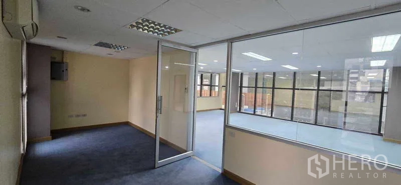 办公空间 出租 - 玻璃隔断办公室，眺望灯光充足的开放式办公区。