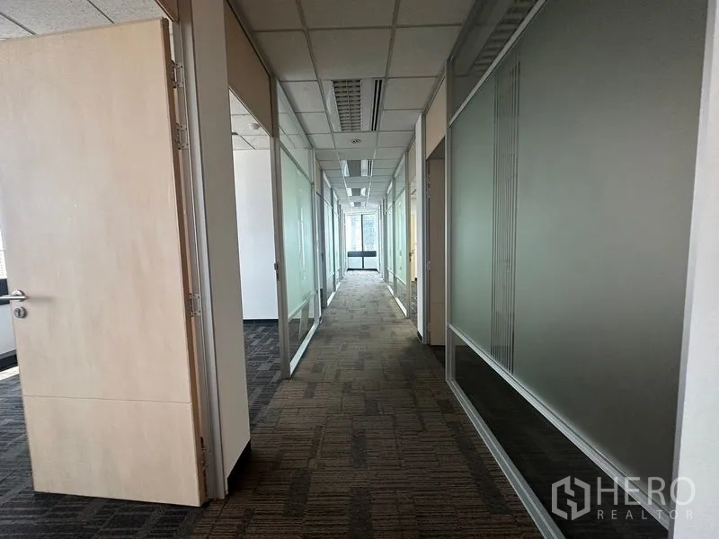 办公空间 出租在Khlong Toei, Bangkok - 走廊通向采光窗，设有多间玻璃隔断房。