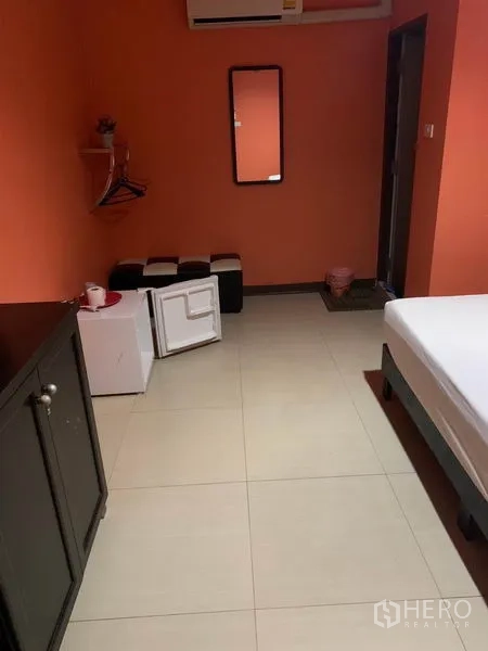 พื้นที่ขายปลีก ให้เช่าในKhlong Toei, Bangkok - ห้องพักโทนสีส้ม มีตู้เย็นขนาดเล็ก กระจก และสตูล