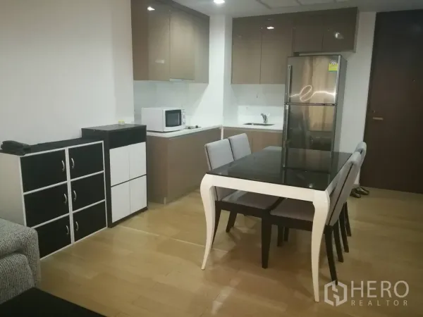 คอนโด ให้เช่าในKhlong Toei, Bangkok - ครัวแบบเปิดพร้อมตู้ลอยเงา ตู้เย็นสแตนเลส ไมโครเวฟ และโต๊ะทานอาหาร พื้นไม้