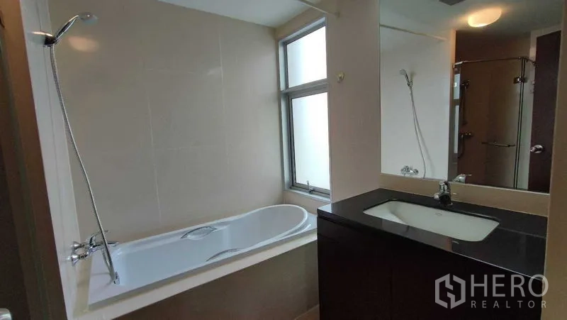 คอนโด ให้เช่าในKhlong Toei, Bangkok - ห้องน้ำพร้อมอ่างอาบน้ำบิวท์อินติดหน้าต่าง เคาน์เตอร์อ่างล้างหน้า และผนังโทนเรียบ