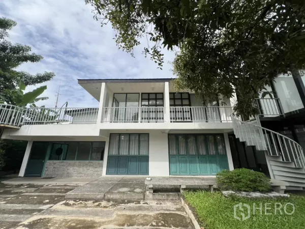 สำนักงานที่บ้าน ให้เช่าหรือขายในPhra Khanong, Bangkok - ด้านหน้าบ้านสีขาวสองชั้น พร้อมระเบียงยาวและลานจอดรถ