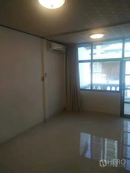 ทาวน์เฮาส์ ให้เช่า - ห้องกว้างพื้นเงา หน้าต่างใหญ่ ผ้าม่าน และทางออกสู่ระเบียง