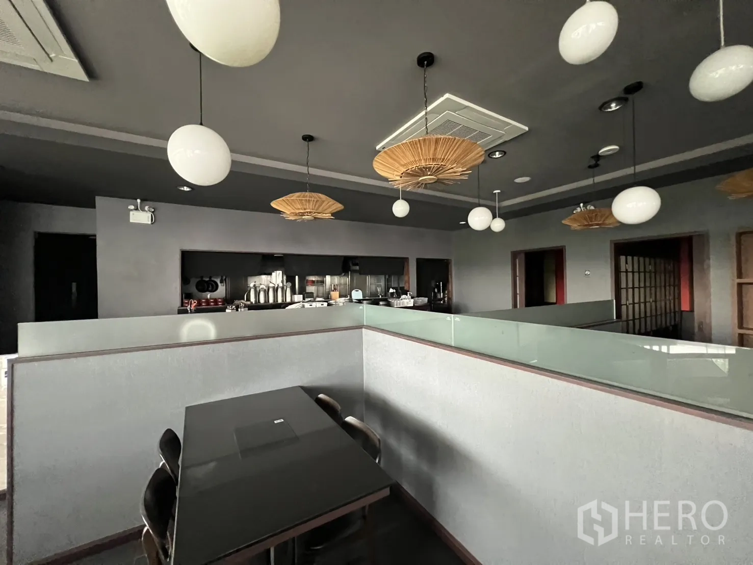 零售空间 for rent in Watthana, Bangkok - 带开放式厨房吧台、圆形吊灯与深色天花的精装零售空间座位区。