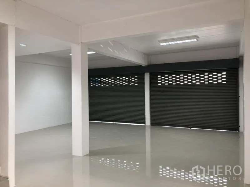 Factory for rent in Pathum Thani - Ground-floor loading area with glossy floor and three roller shutters.