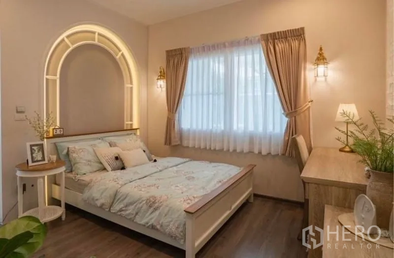 Detached House for rent in Bang Phli, Samut Prakan - Warm-toned guest bedroom with arched headboard lighting and writing desk.