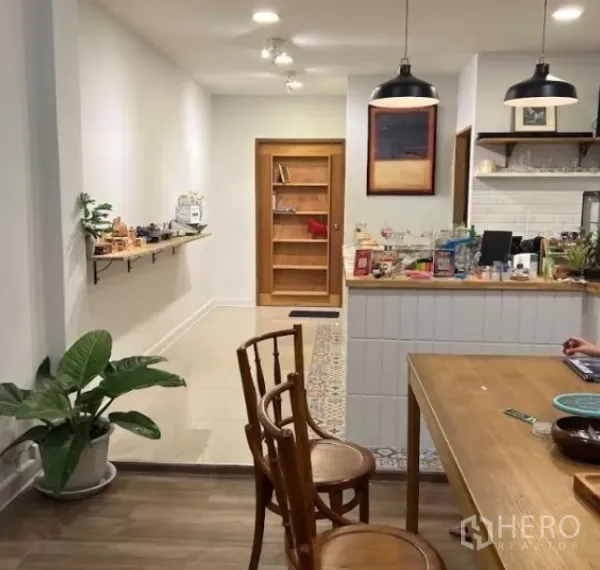 店屋 出租在Watthana, Bangkok - 店铺内部温馨照明，木质吧台、吊灯与座位区。