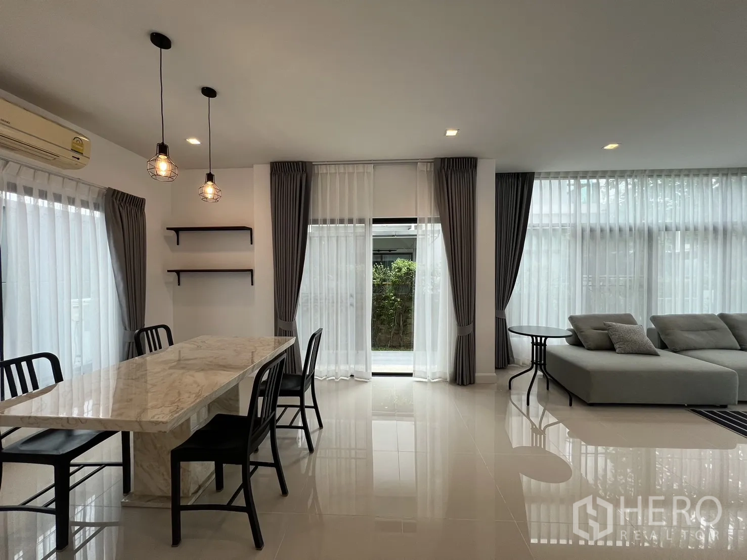 独立式住宅 出租在Bang Kapi, Bangkok - 餐厨一角，吊灯与通高窗营造明亮氛围。