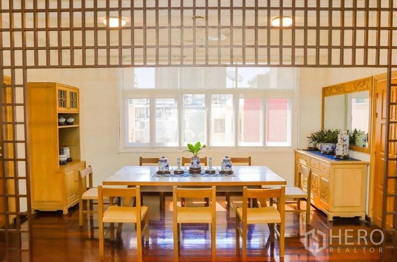 อพาร์ทเมนท์ ให้เช่าในPathum Wan, Bangkok - โซนรับประทานอาหารสว่าง กำแพงฉลุลายไม้ หน้าต่างบานกว้าง และโต๊ะยาวรองรับแปดที่นั่ง