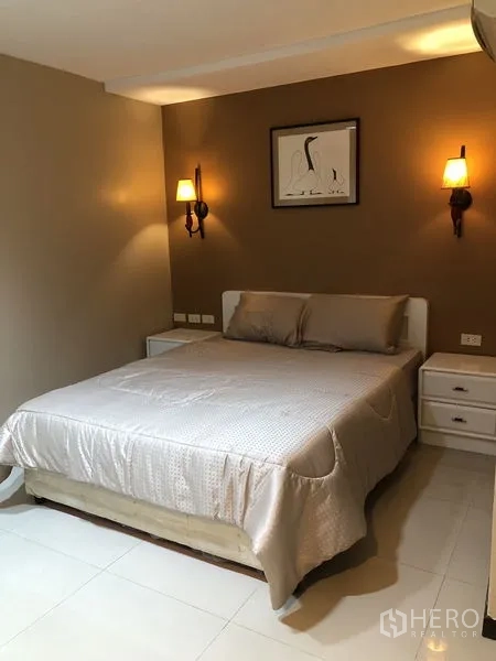 Condominium for rent in Khlong Toei, Bangkok - Second bedroom with double bed, soft lighting and bedside tables.