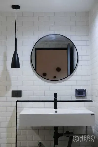 公寓 出租在Bang Rak, Bangkok - 浴室洗手台，圆镜与黑色吊灯。