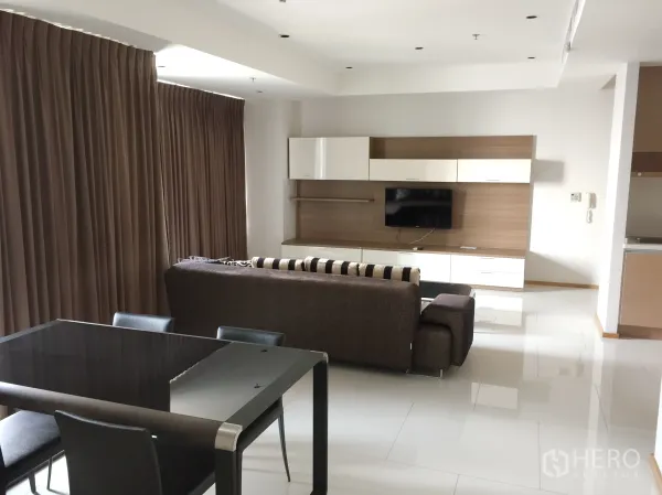 คอนโด ให้เช่าในKhlong Toei, Bangkok - ห้องนั่งเล่นและรับประทานอาหารแบบโอเพ่นแปลน โซฟา ทีวีบิลต์อิน และผ้าม่านเต็มความสูง ในคอนโดโมเดิร์น