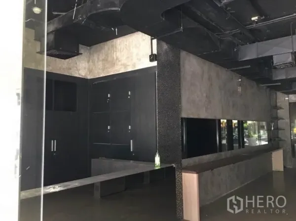 办公空间 出租在Pathum Wan, Bangkok - 长形办公区，水泥质感墙面、镜面装饰与外露通风管道。