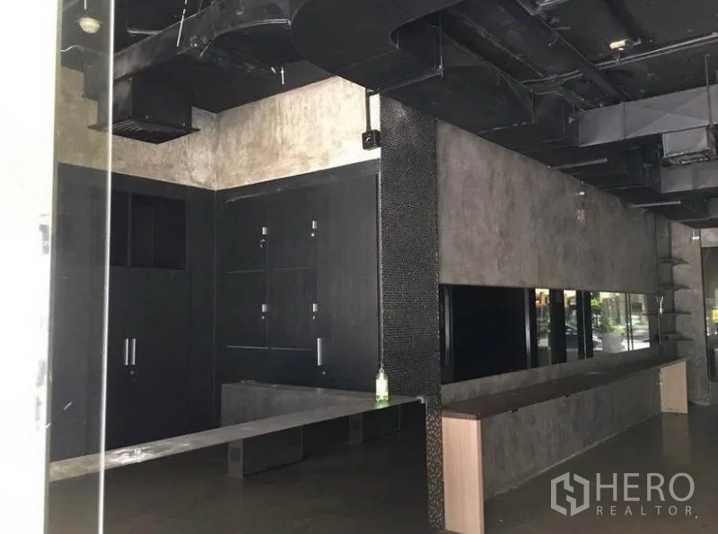 办公空间 出租在Pathum Wan, Bangkok - 长形办公区，水泥质感墙面、镜面装饰与外露通风管道。