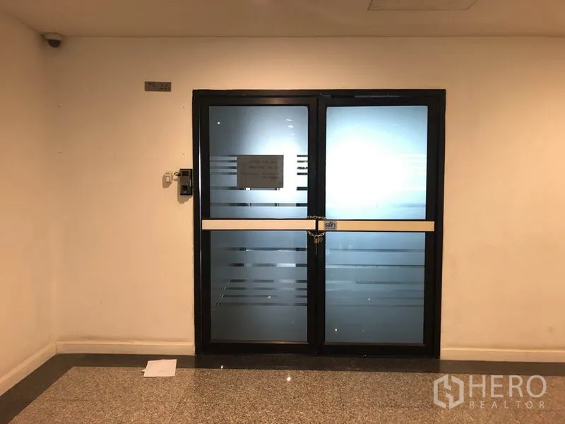 办公空间 出租在Watthana, Bangkok - 大楼走廊中的双扇磨砂玻璃办公室入口，带门禁