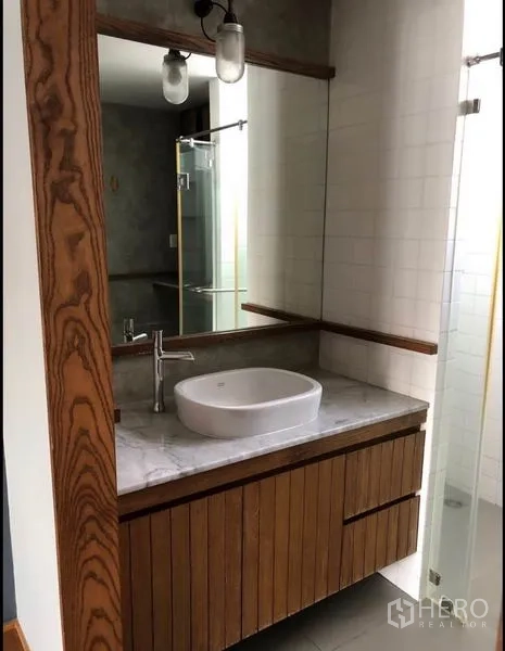 联排别墅 出售在Wang Thonglang, Bangkok - 浴室梳妆台，圆形台盆、大理石台面与木框镜。