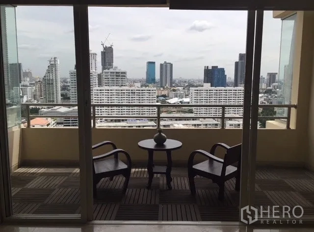 Condominium for rent in Watthana, Bangkok - Covered balcony with two chairs and table facing a panoramic Bangkok skyline.