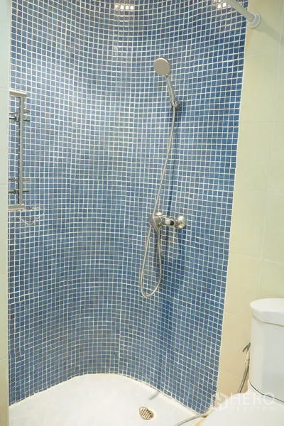 Condominium for rent in Pathum Wan, Bangkok - Bathroom with blue mosaic tiled shower and handheld showerhead.