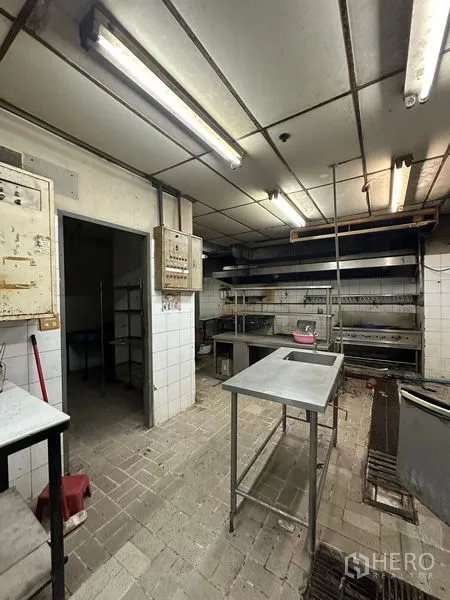 零售空间 出租在Yan Nawa, Bangkok - 厨房备餐区配不锈钢工作台、置物架与砖地面。