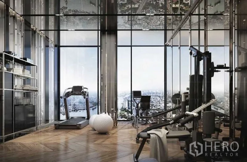 Condominium for sale in Bangkok - Private fitness room with gym equipment, mirrored walls and skyline panorama.