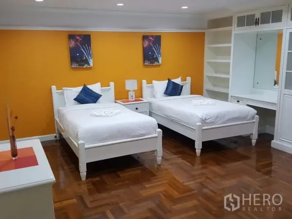 คอนโด ให้เช่าในWatthana, Bangkok - ห้องนอนเตียงคู่ ผนังสีส้ม เตียงสีขาว ตู้เสื้อผ้าบิวท์อินและชั้นวางของ