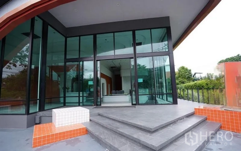 独立商业地产 出租在Bang Na, Bangkok - 主入口台阶通向高挑玻璃门与有顶门廊。