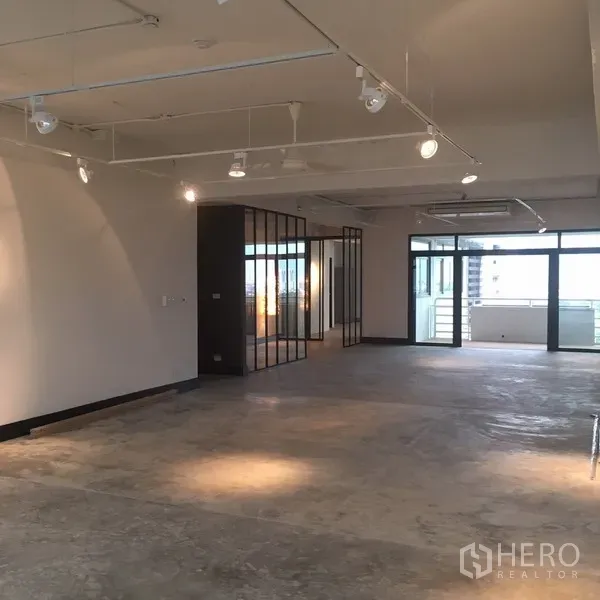 คอนโด ให้เช่าในWatthana, Bangkok - ห้องนั่งเล่นแบบโอเพ่นแพลน เพดานรางไฟ ฉากกั้นกระจก และประตูกระจกเปิดสู่ระเบียง.