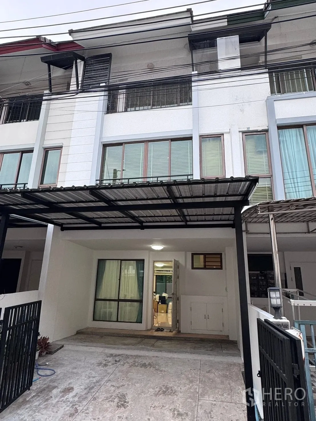 联排别墅 for rent in Phra Khanong, Bangkok - 联排别墅外立面，带栅栏车棚与阳台。