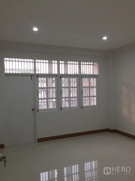 店屋 出租在Suan Luang, Bangkok - 采光充足的卧室，设大面积带护栏窗户与亮面地砖。