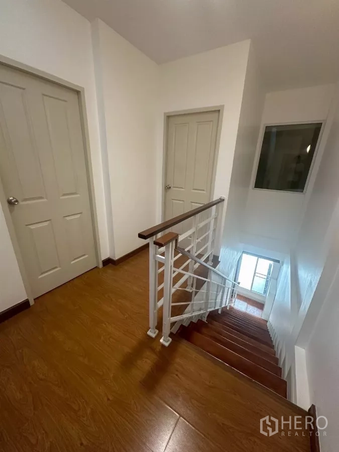 Townhouse for rent in Chom Thong, Bangkok - Upper landing looking down the staircase with natural light.