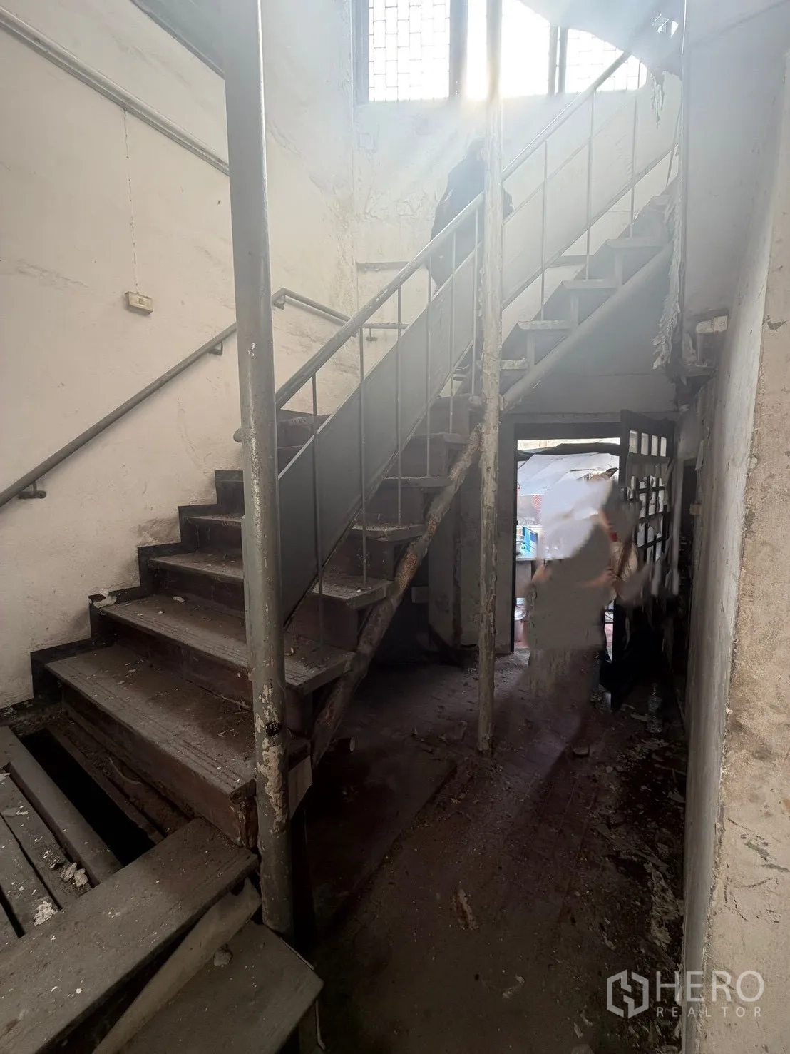 Shophouse for rent in Watthana, Bangkok - Aged stairwell with metal handrails and peeling finishes.