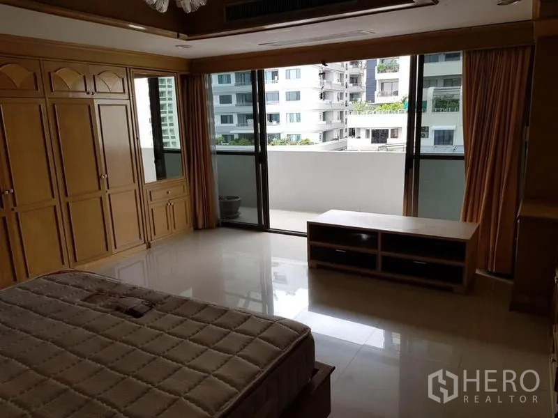 คอนโด ให้เช่าหรือขายในWatthana, Bangkok - ห้องนอนขนาดใหญ่ ประตูกระจกเต็มบานเปิดสู่ระเบียง และตู้เสื้อผ้าติดผนัง