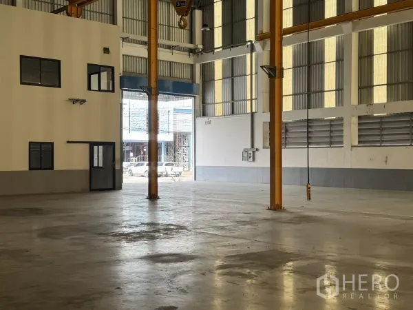工厂 出租或出售在Bang Phli, Samut Prakan - 宽敞仓库内景，面向卷帘门与邻接办公室。