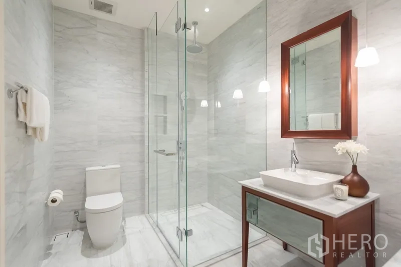 คอนโด ขายในWatthana, Bangkok - ห้องน้ำหินอ่อนพร้อมตู้กระจกอาบน้ำ อ่างล้างหน้า และไฟห้อยสวยงาม