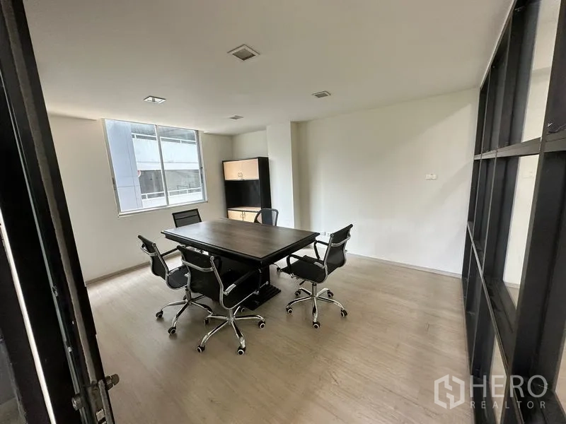 Office Space for rent in Khlong Toei, Bangkok - Bright meeting room with rectangular table, swivel chairs, and natural light from a window.