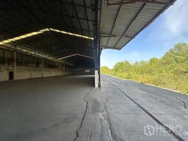 货栈 出租在Wang Noi, Phra Nakhon Si Ayutthaya - 半开放装卸区，带雨棚与宽阔卡车通道，旁为绿化带。