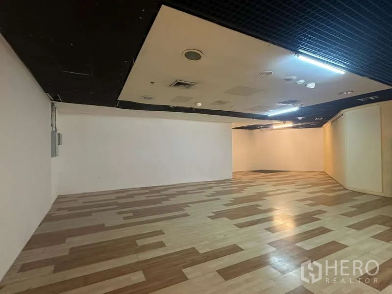 零售空间 出租 - 开放式零售空间，木纹地板与黑色吊顶照明。