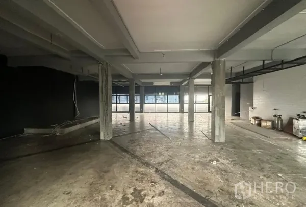 零售空间 出租 - 空置零售层的宽阔视角，展示结构梁与大片玻璃采光。