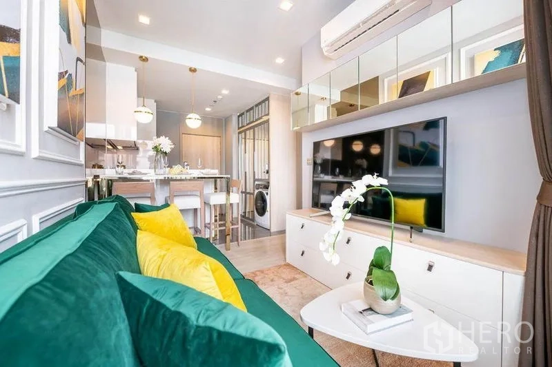 公寓 出租或出售在Watthana, Bangkok - 客厅面向电视与储物柜，滑门通往阳台及餐厨区。