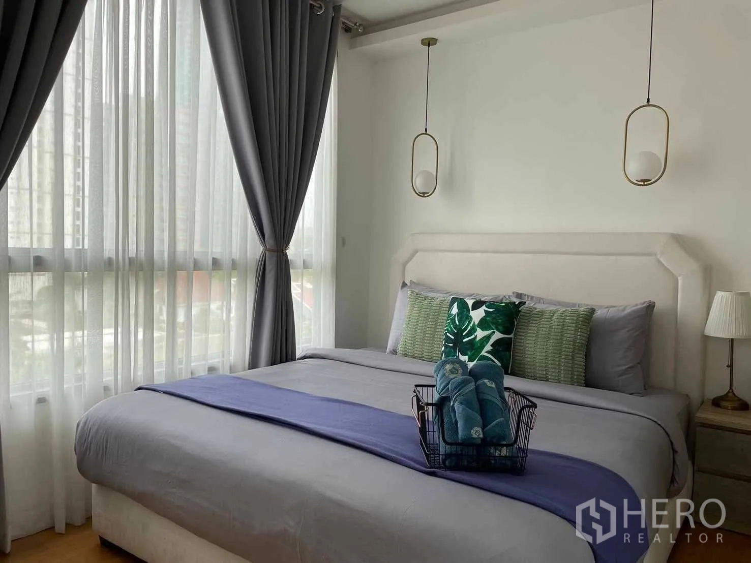 公寓 for rent in Watthana, Bangkok - 转角卧室设大窗与吊灯，配特大床，可见城市景观。