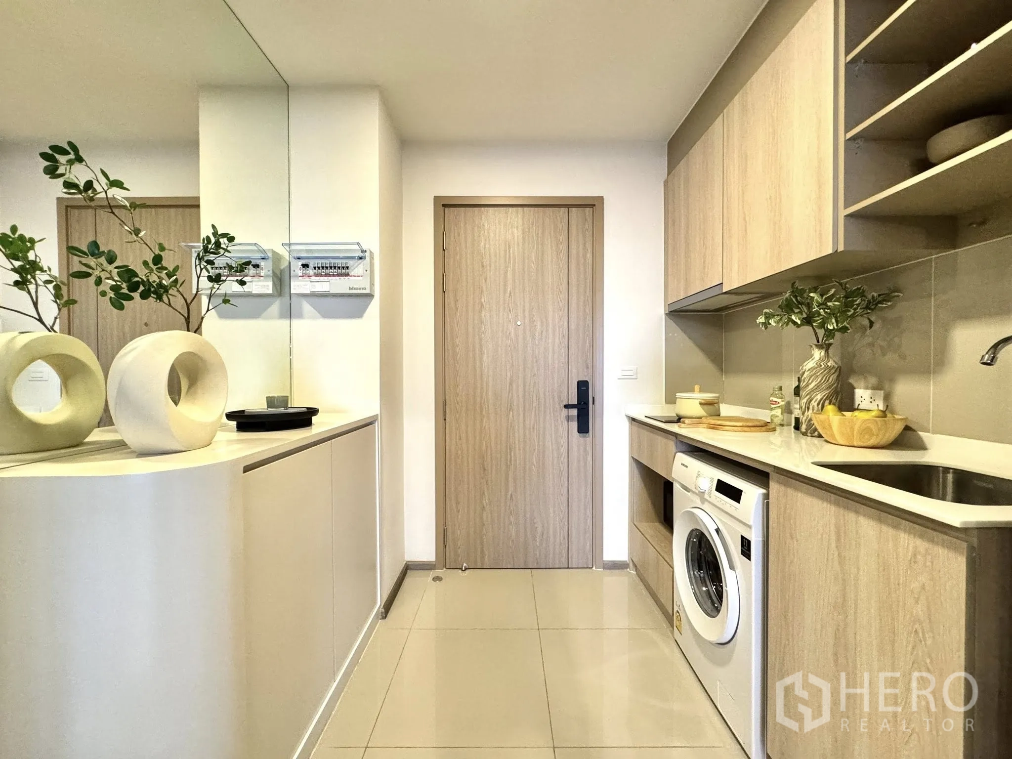 公寓 for rent in Watthana, Bangkok - 一字型厨房配浅木柜体、台面、水槽与洗衣机。