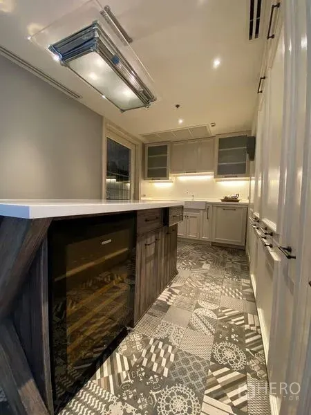 Condominium for rent in Khlong San, Bangkok - Galley kitchen with patterned tile flooring, island counter and built‑in cabinetry.