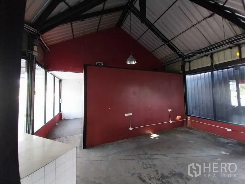 零售空间 出租在Khlong Toei, Bangkok - 工业风店内，红色隔墙、外露梁架与充足采光。