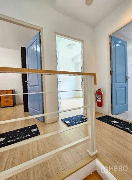 สำนักงานที่บ้าน ให้เช่าหรือขายในSuan Luang, Bangkok - โถงบันไดสว่าง ราวไม้ พร้อมประตูสามห้องชั้นบน